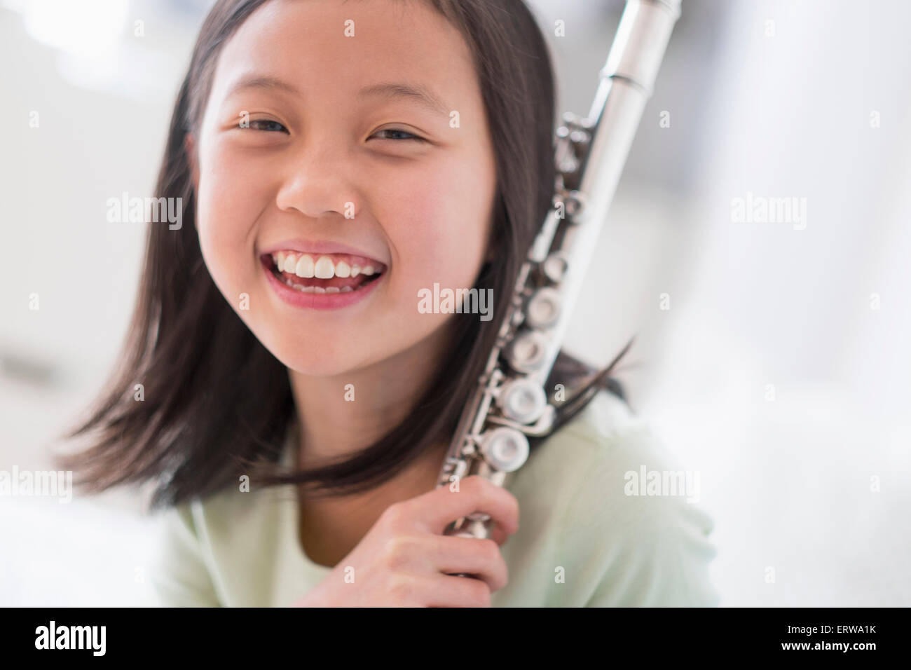 Smiling Chinese girl holding flute Stock Photo