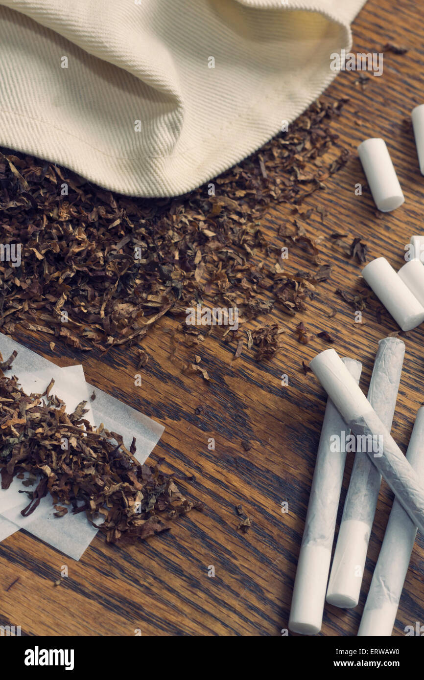 Rolling cigarettes with filters papers and plenty finely cut tobacco