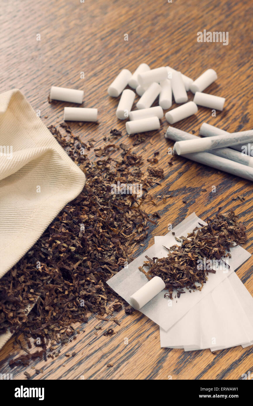 Rolling cigarettes with filters papers and plenty finely cut tobacco Stock  Photo