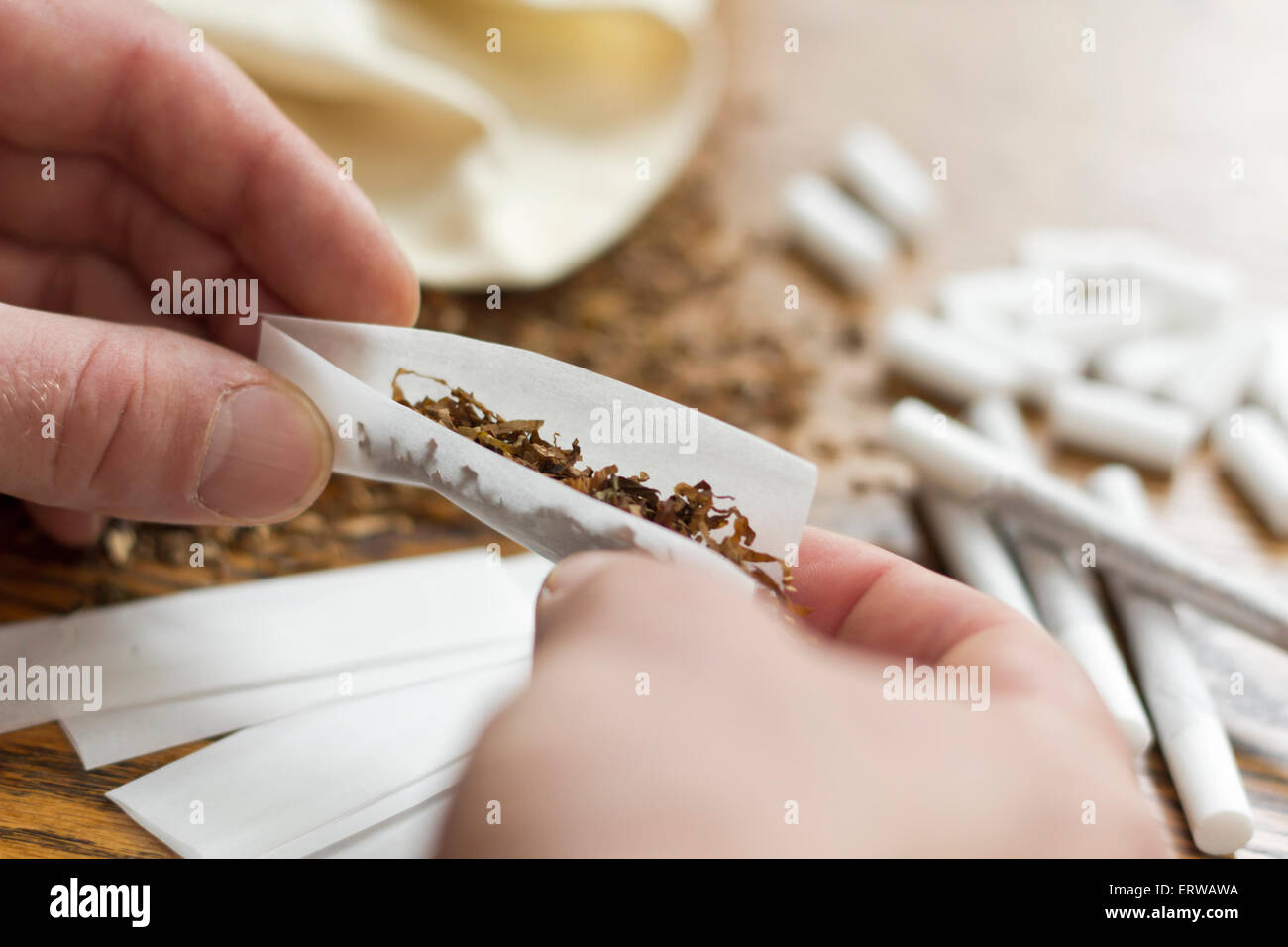 Rolling cigarettes with filters papers and plenty finely cut tobacco