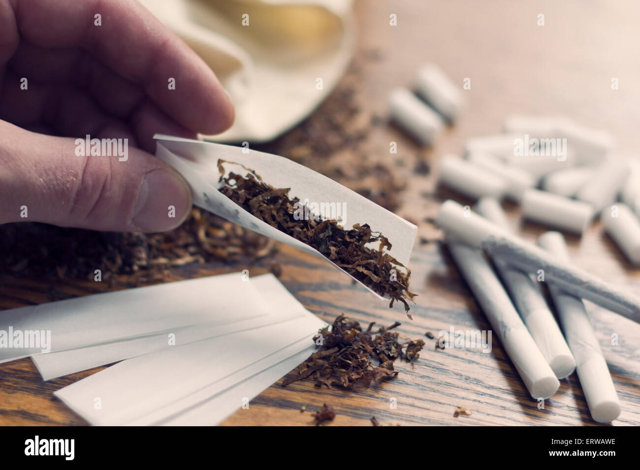 Rolling cigarettes with filters papers and plenty finely cut tobacco