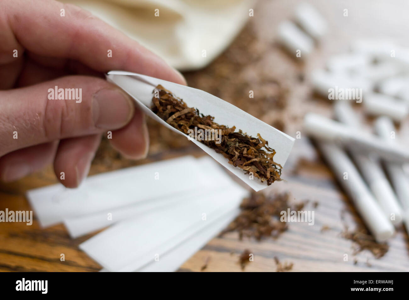 Rolling cigarettes with filters papers and plenty finely cut tobacco Stock Photo Alamy