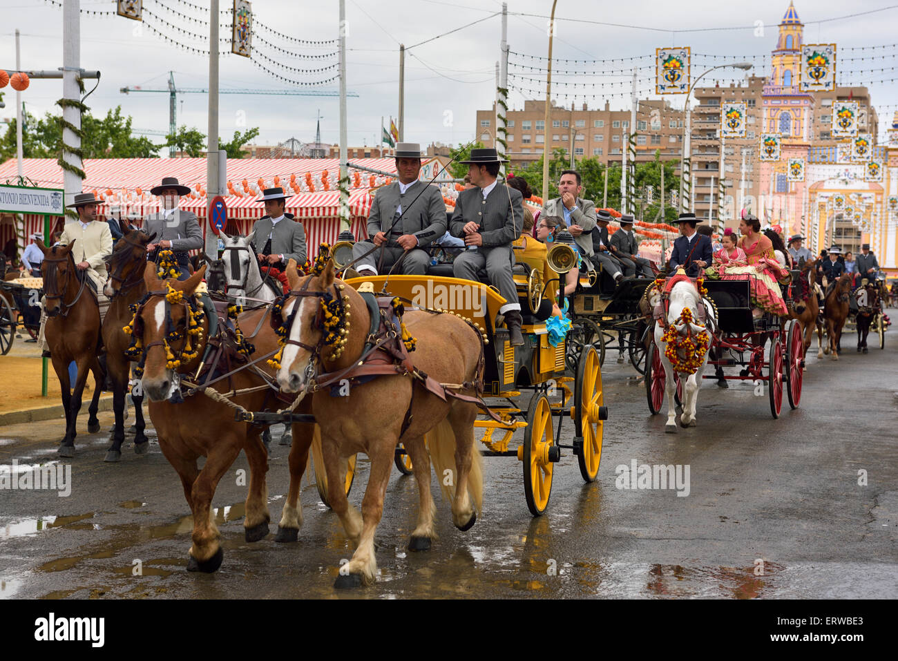 Line of horse drawn carriages with families and riders at the Main Gate 2015 Seville April Fair Stock Photo