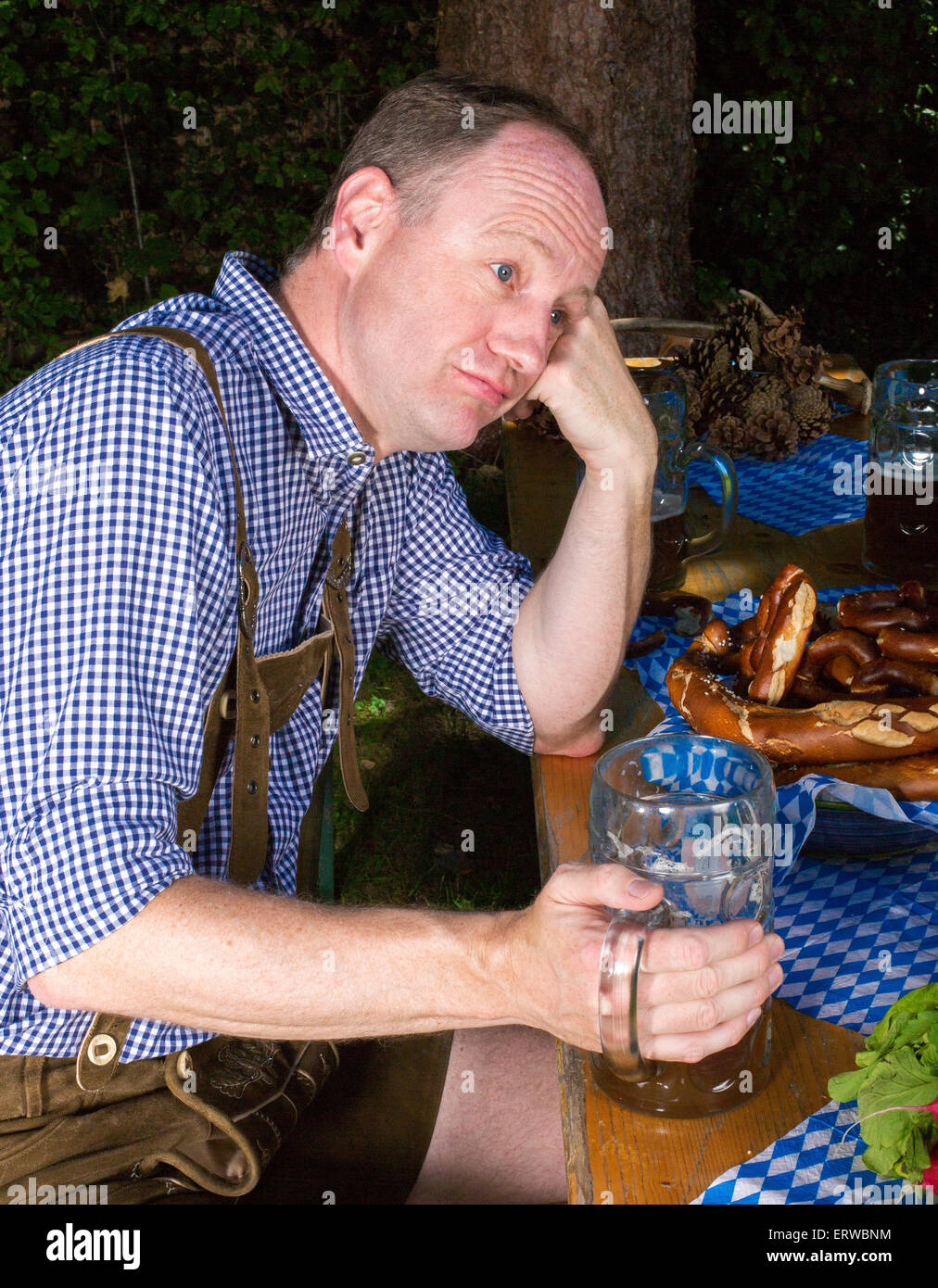 bavarian man sitting on bench with a beer mug Stock Photo