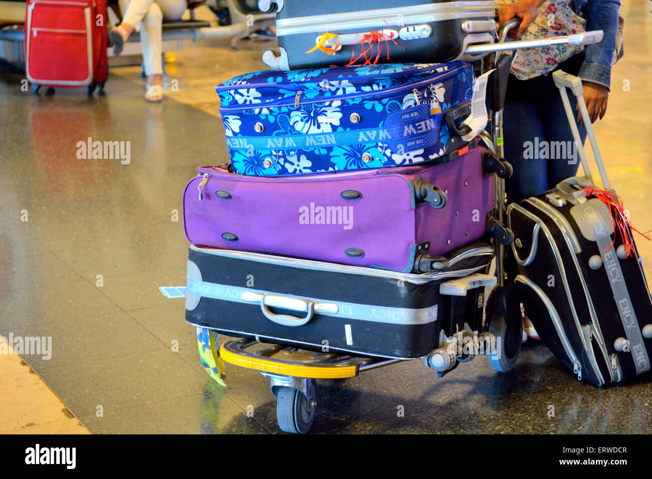 Suitcases stacked on airport trolley Stock Photo