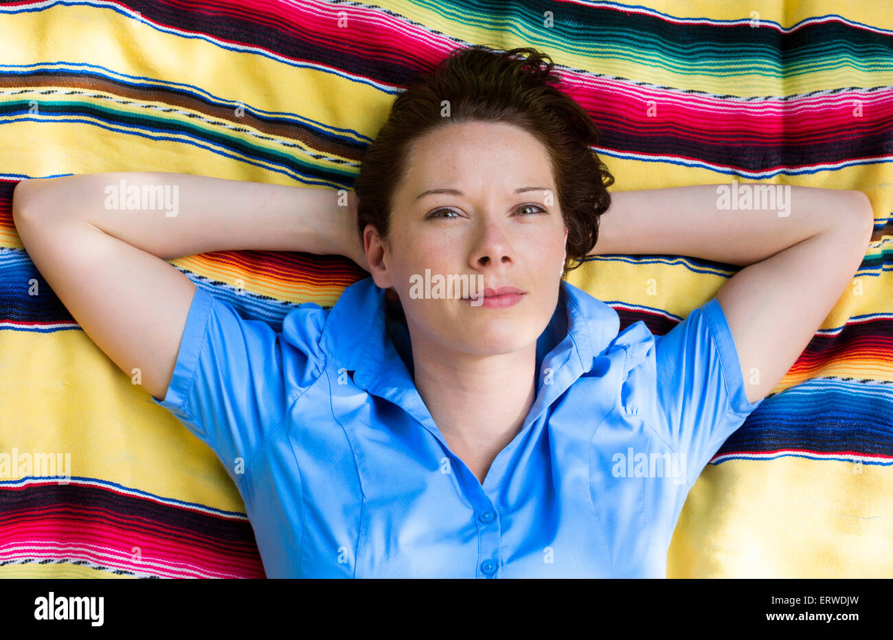young woman is lying on a blanket on grass and smiles Stock Photo Alamy