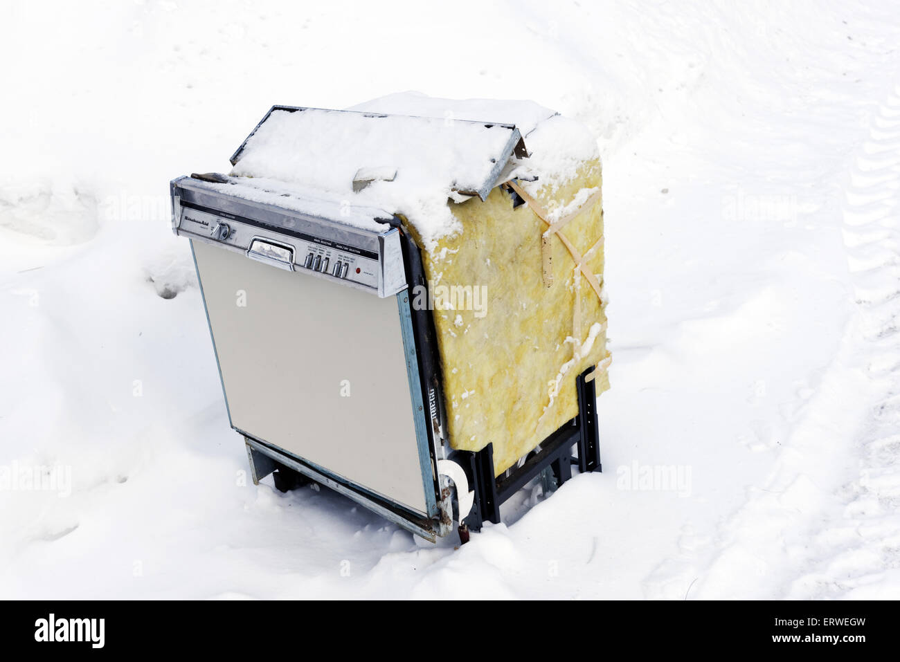 An old dishwasher dumped in the snow Stock Photo