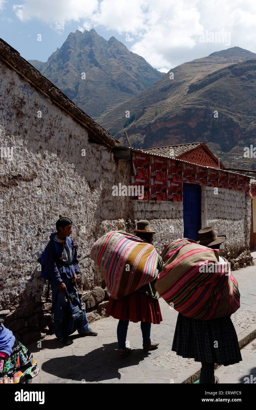 Two ladies carrying big bundles on their backs in the Peruvian town of Pisac Stock Photo