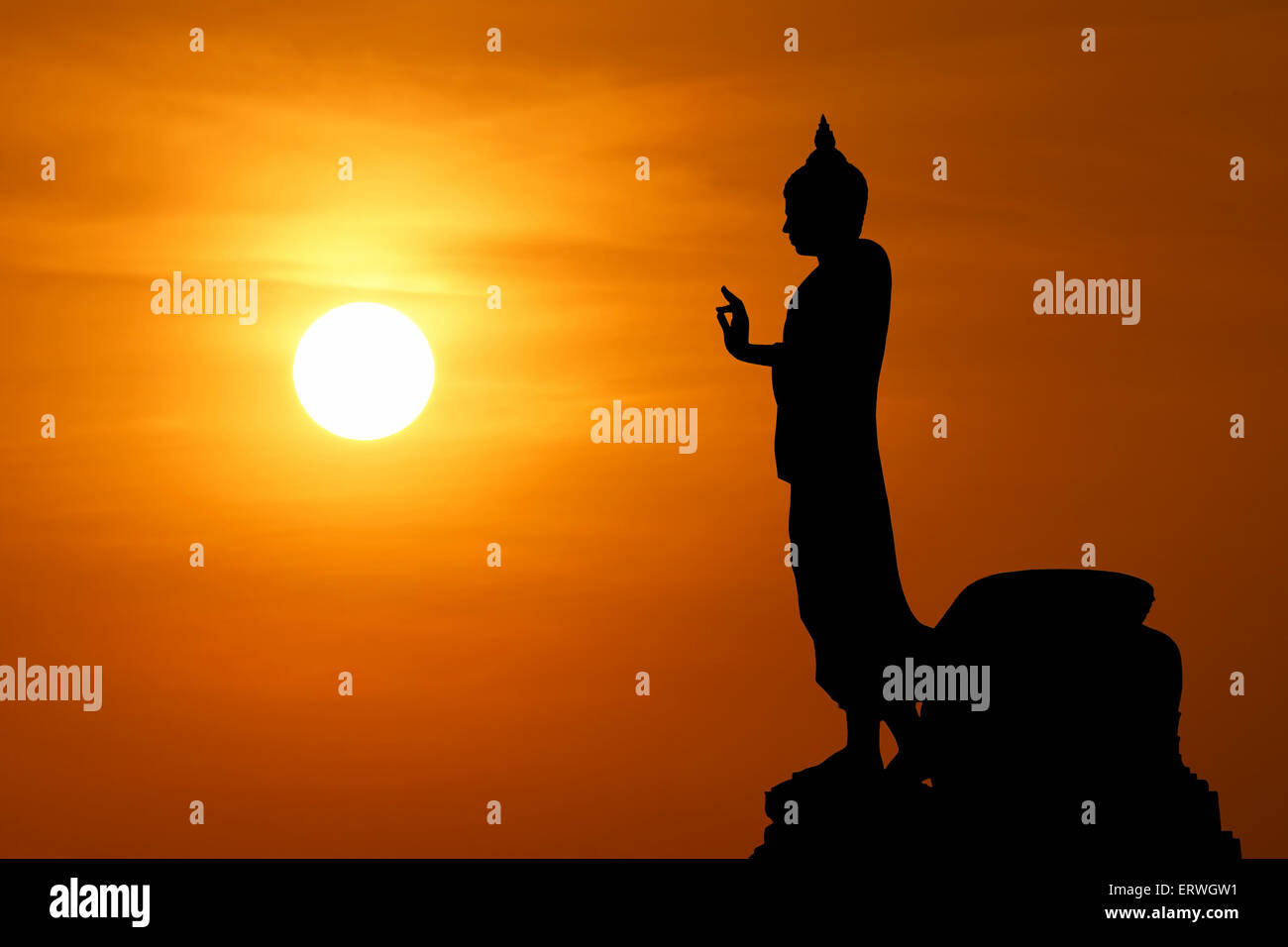 silhouette of  buddha image with beautiful sunset background Stock Photo