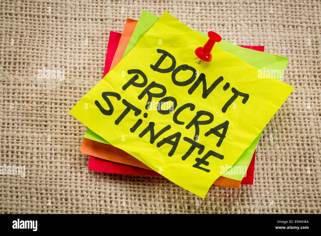 do not procrastinate reminder on a yellow sticky note Stock Photo