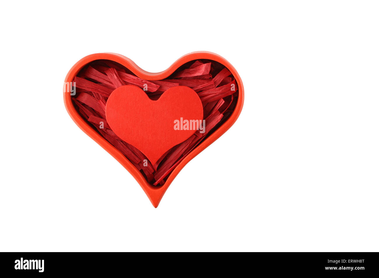 Red painted wooden heart enclosed with red paper raffia strips in red box isolated on white