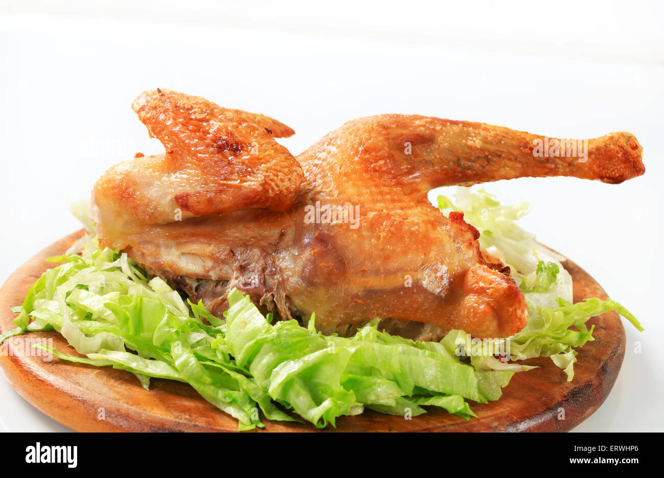 Crispy skin roast chicken with shredded lettuce on cutting board Stock ...