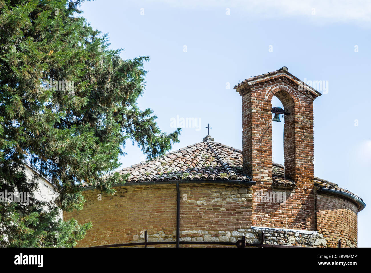 Catholic baptistery church of the thirteenth century with brick wall and small bell in village of the Italian countryside Stock Photo