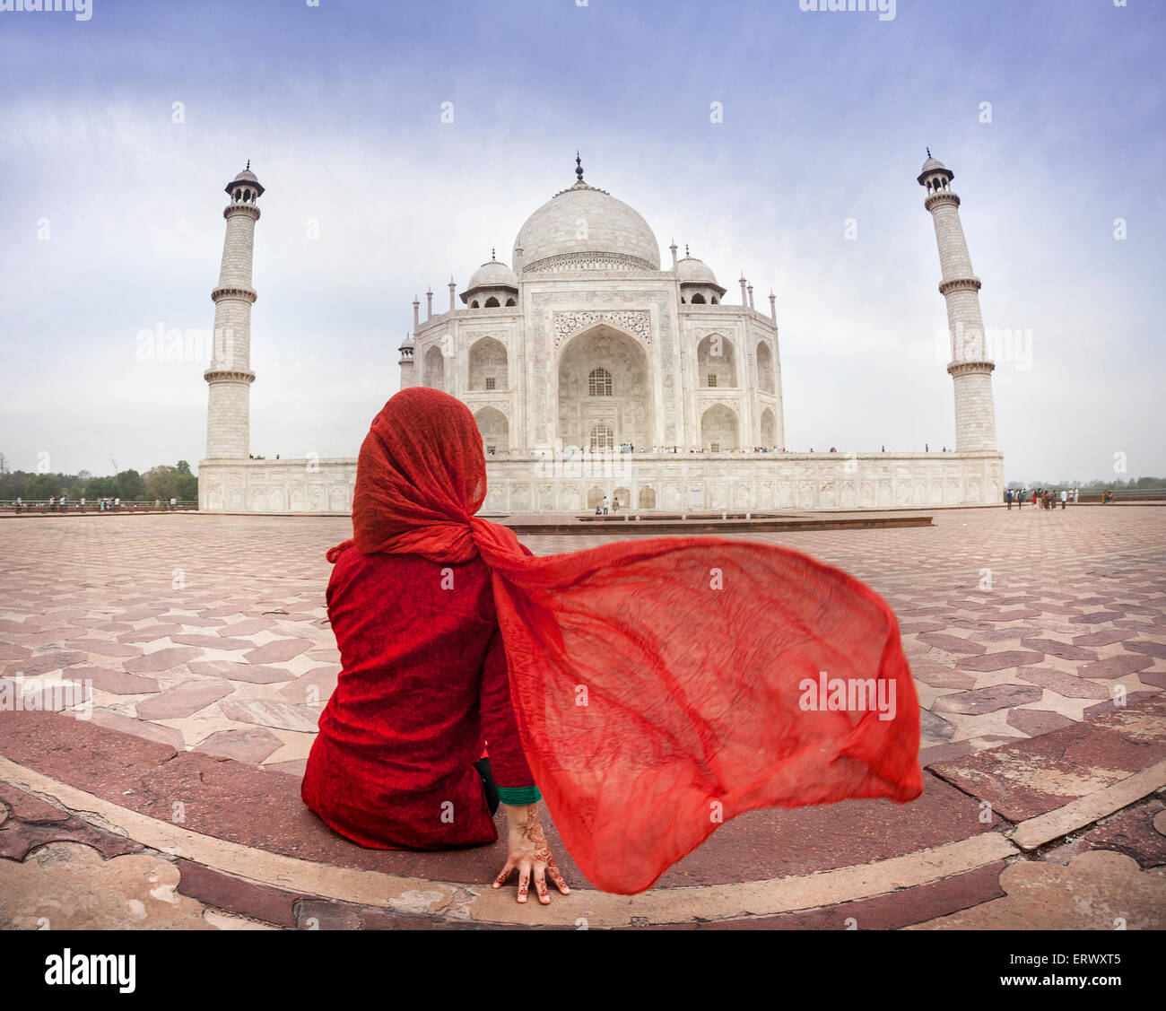 Woman in red costume with flattering scarf sitting near Taj Mahal in Agra, Uttar Pradesh, India Stock Photo