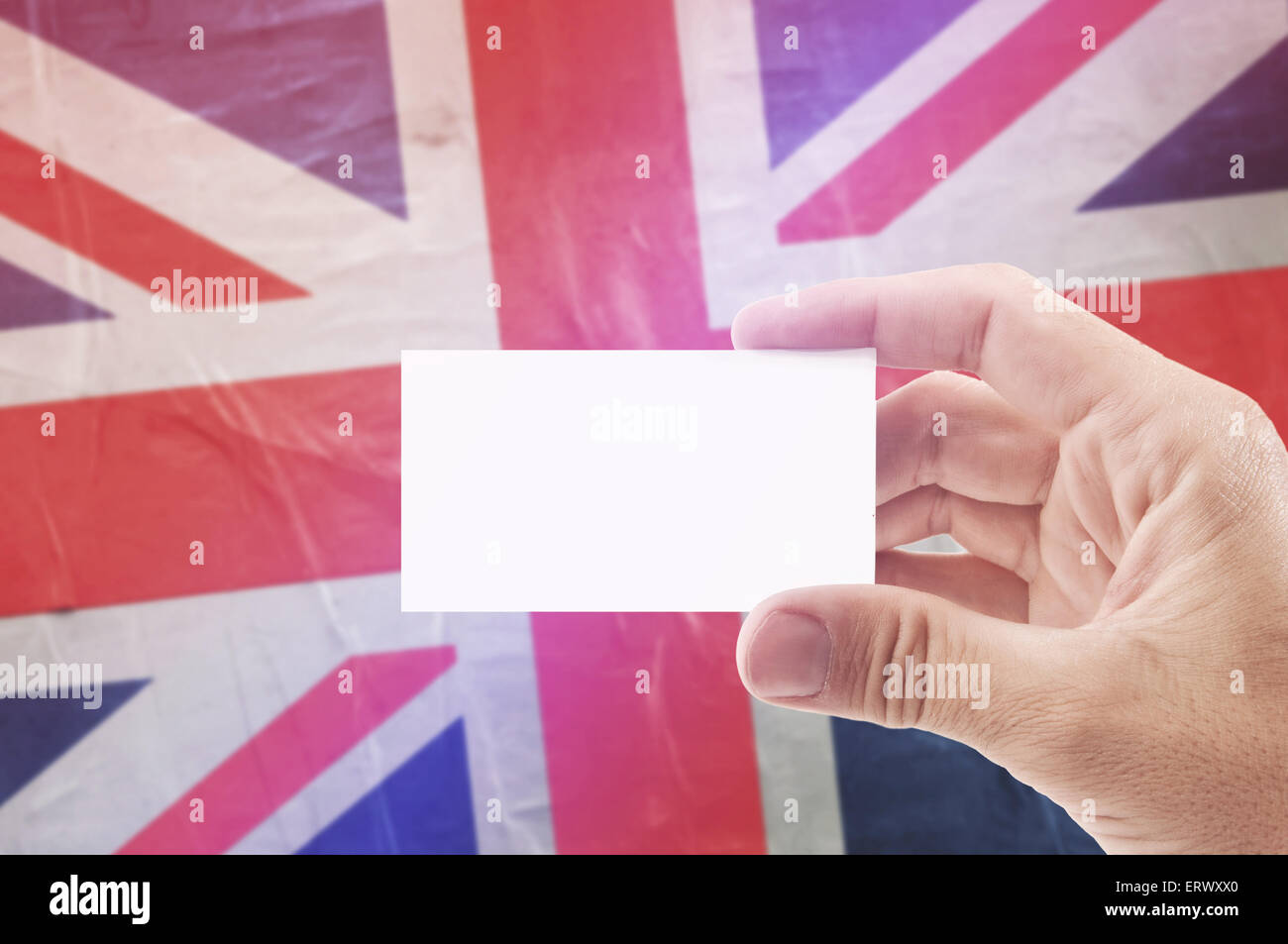 Caucasian Man Holding Blank Business Card Against United Kingdom of Great Britain Flag, Retro Vintage Rustic Tone Effect Stock Photo