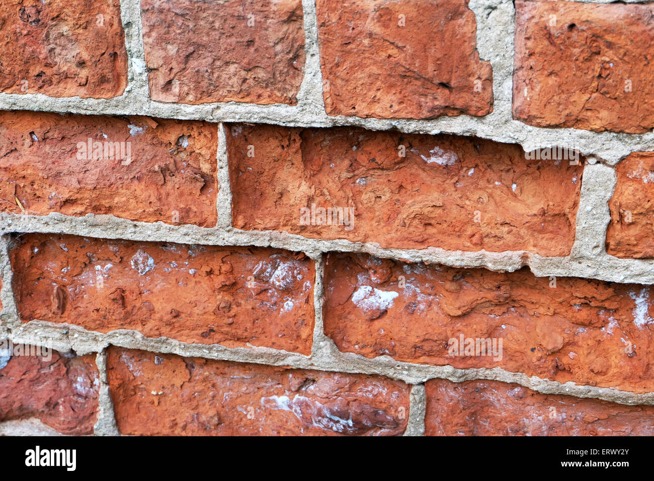 Old bricks corroding in wall with stronger concrete. Stock Photo