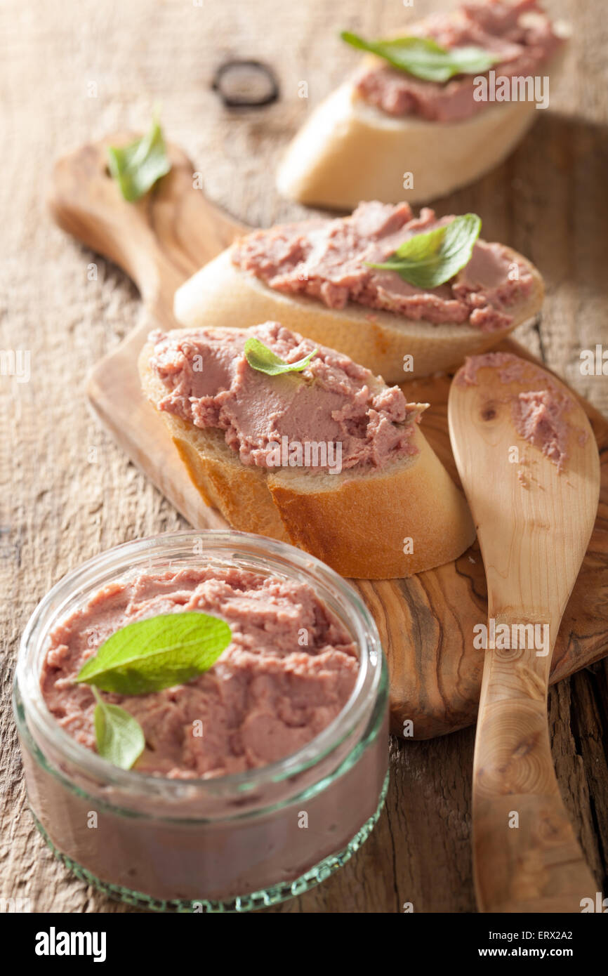 healthy chicken liver pate with sage in jar and on bread Stock Photo