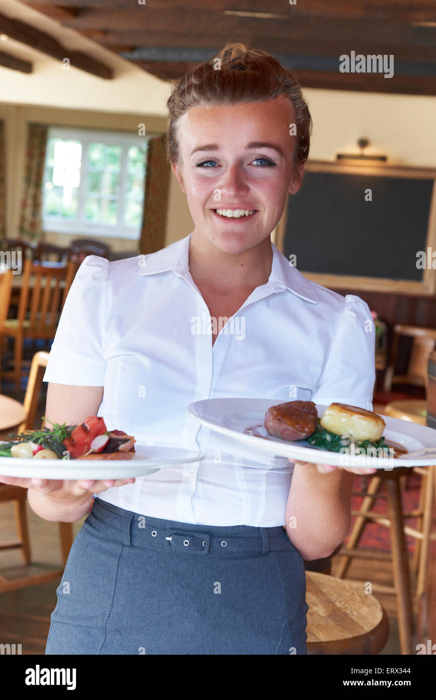Portrait Of Waitress Serving Food In Restaurant Stock Photo
