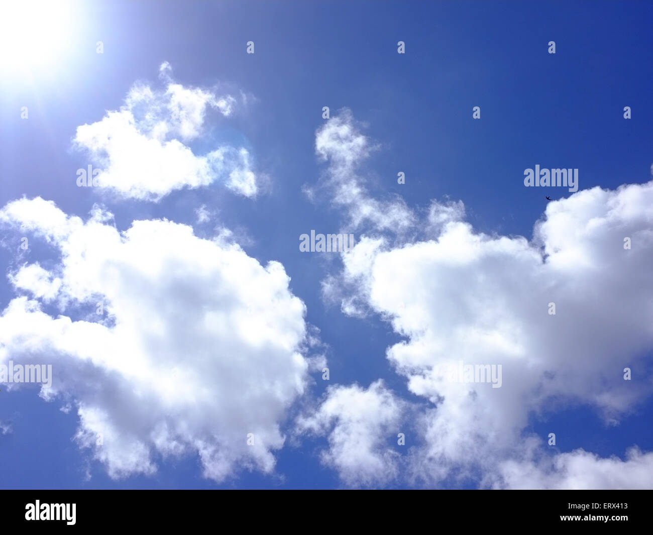 A sunny blue sky with bright puffy white clouds Stock Photo - Alamy