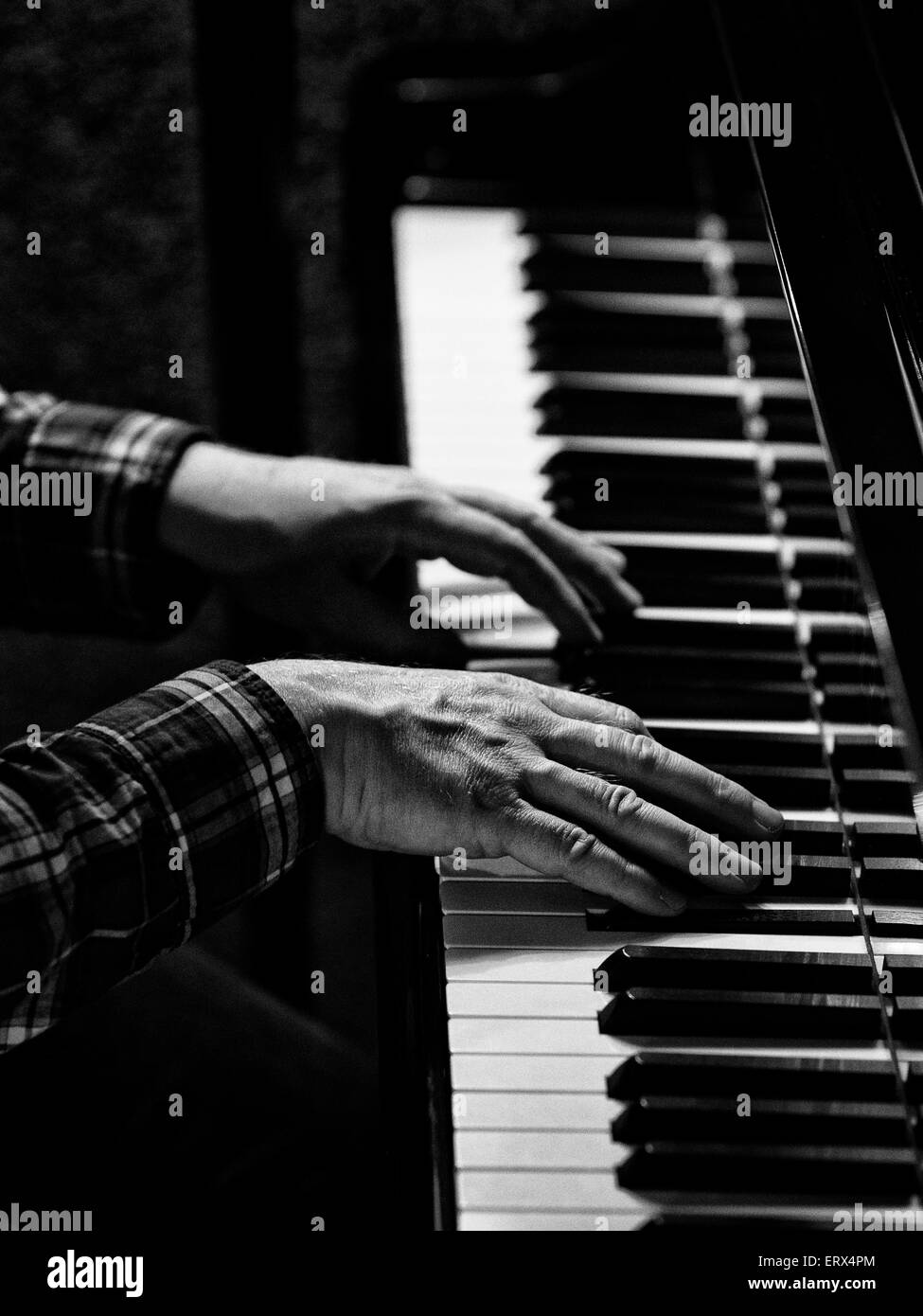 A pianoplayers hands on a piano keyboard Stock Photo