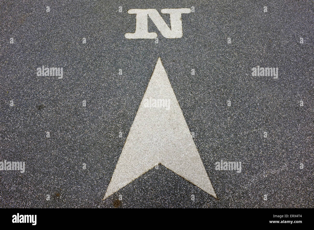 An arrow indicating the direction of North painted onto tarmac. Stock Photo