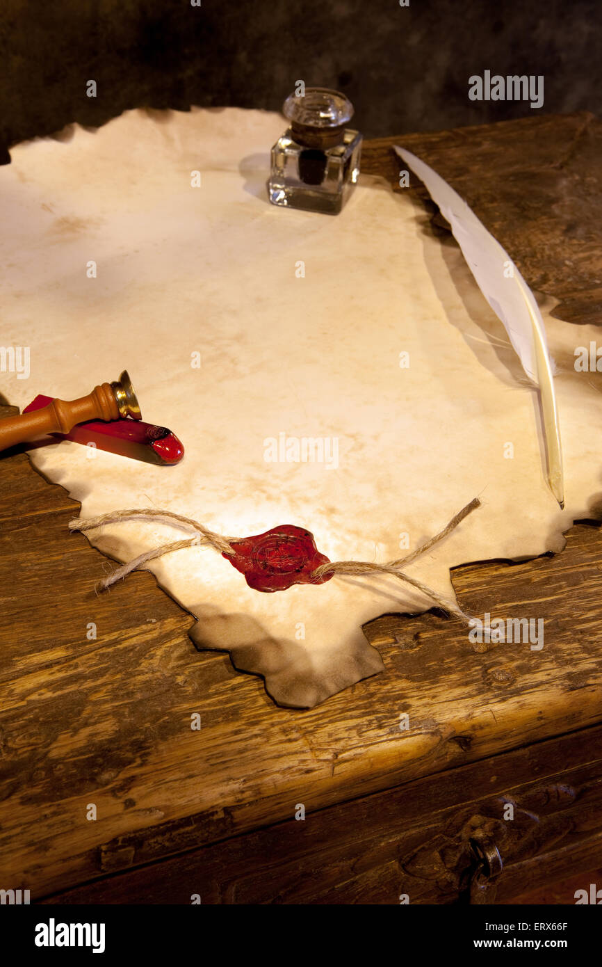 Empty parchment scroll with wax seal and feather quill Stock Photo