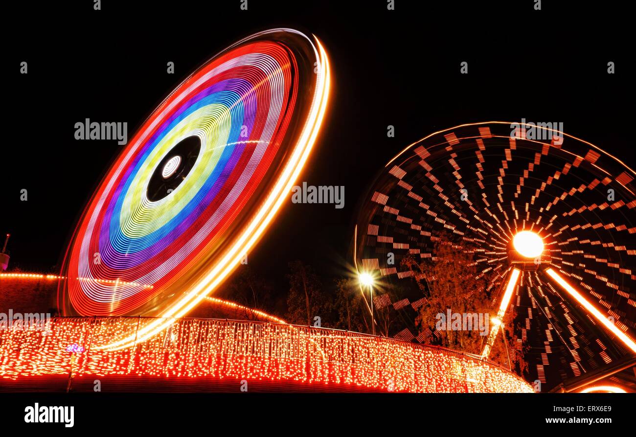Ferris wheel and a ride during the Carnival of Light festival in Linnanmäki amusement park in Helsinki, Finland Stock Photo
