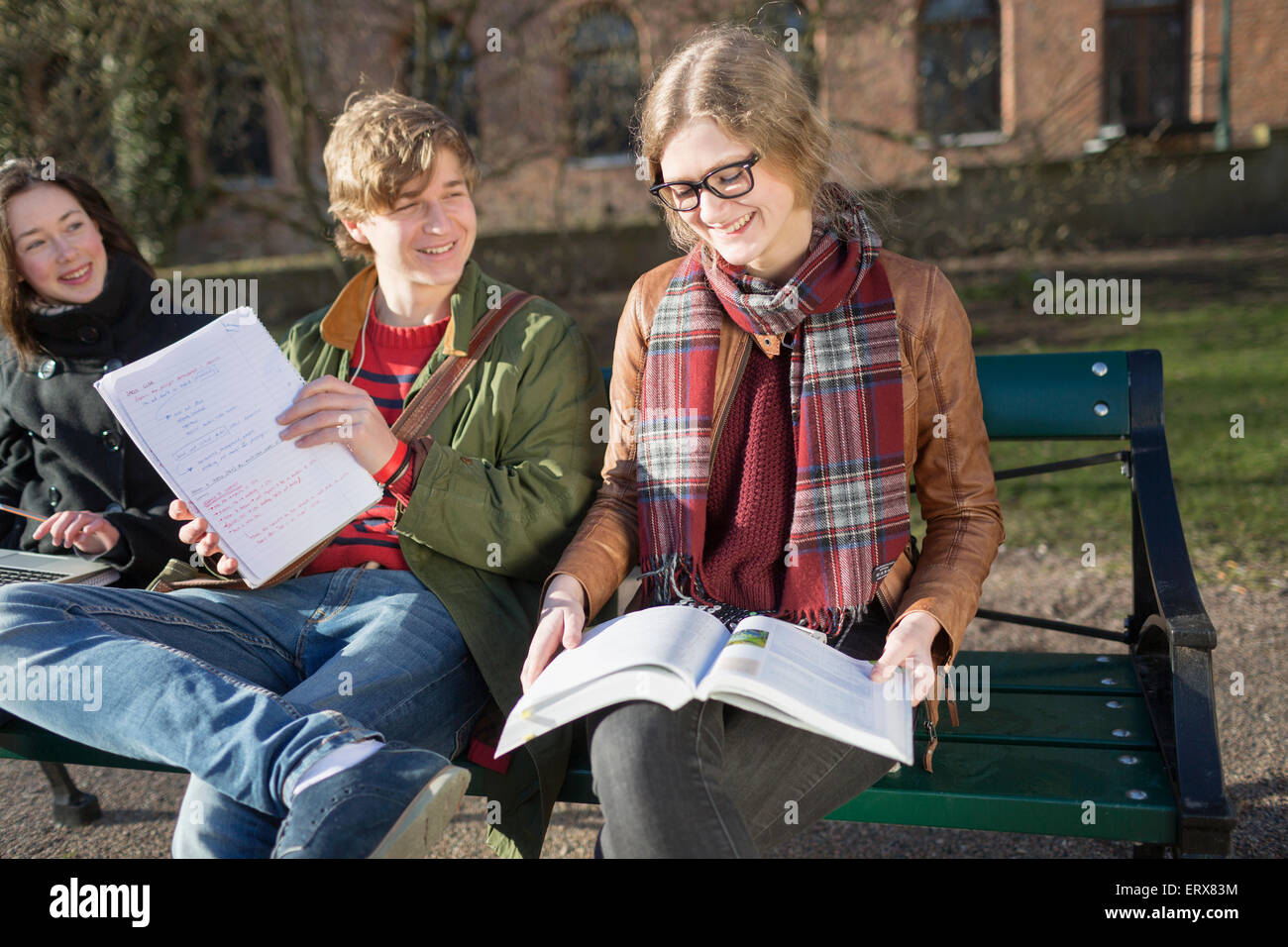 Smiling teenage friends studying in college campus Stock Photo