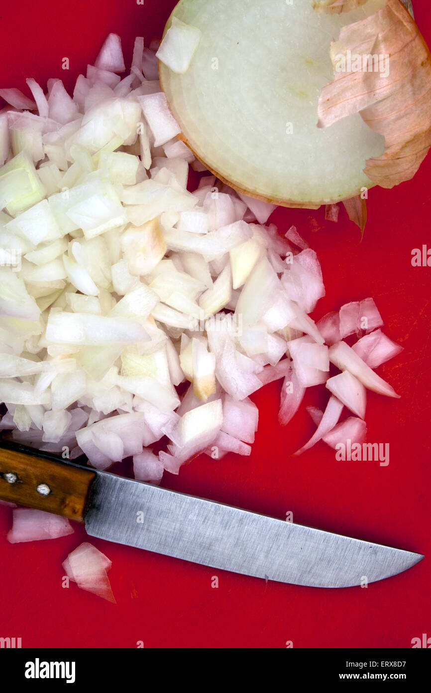 a bunch of chopped onion and a knife over a red board Stock Photo Alamy