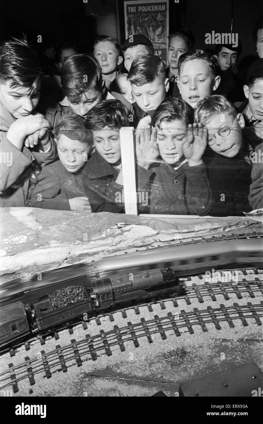 School boys at the 1948 Model Engineer Exhibition at Seymour Hall, London. Children with their faces pressed up to the glass watching a model train set in action. January 1948 Stock Photo