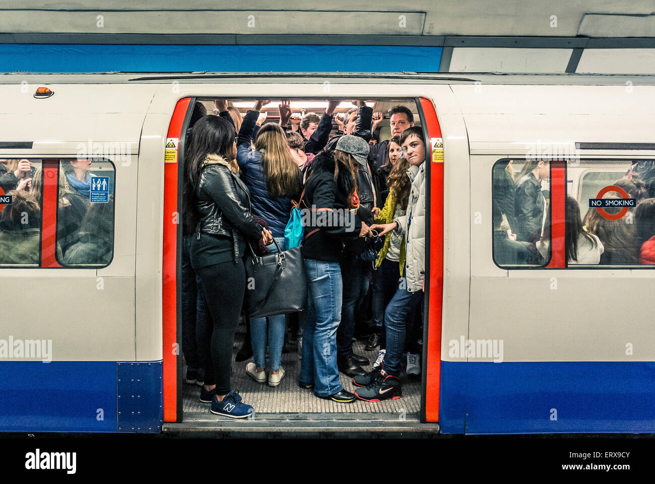 Tube train full of people on London underground - doors open Stock Photo