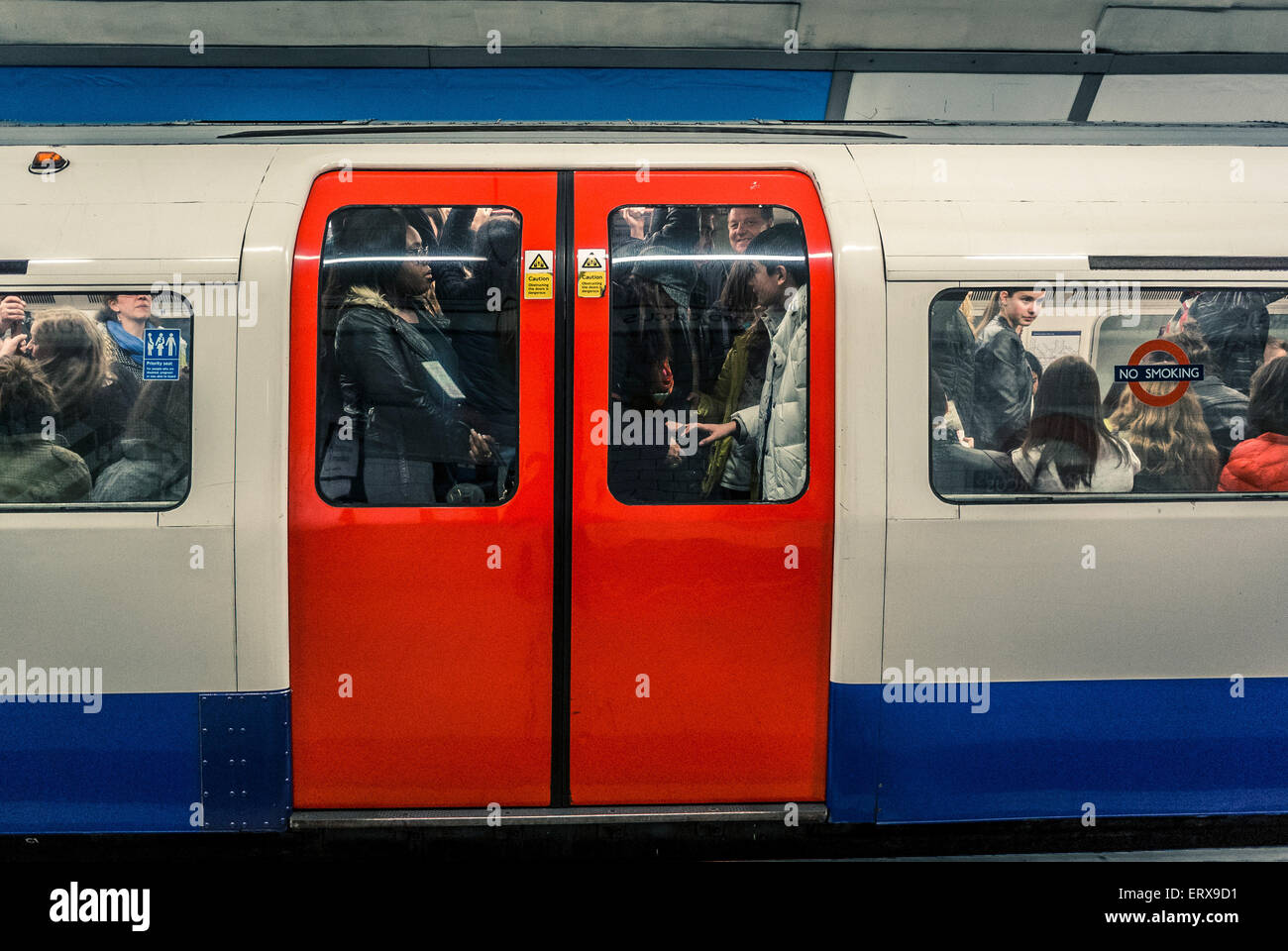Tube train full of people on London underground - doors closed Stock Photo