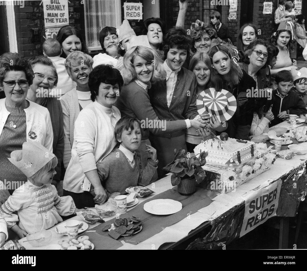 Residents of Paley Street, Anfield, cut a cake to celebrate Liverpool's F.A. cup victory during a street party. 25th May 1976 Stock Photo