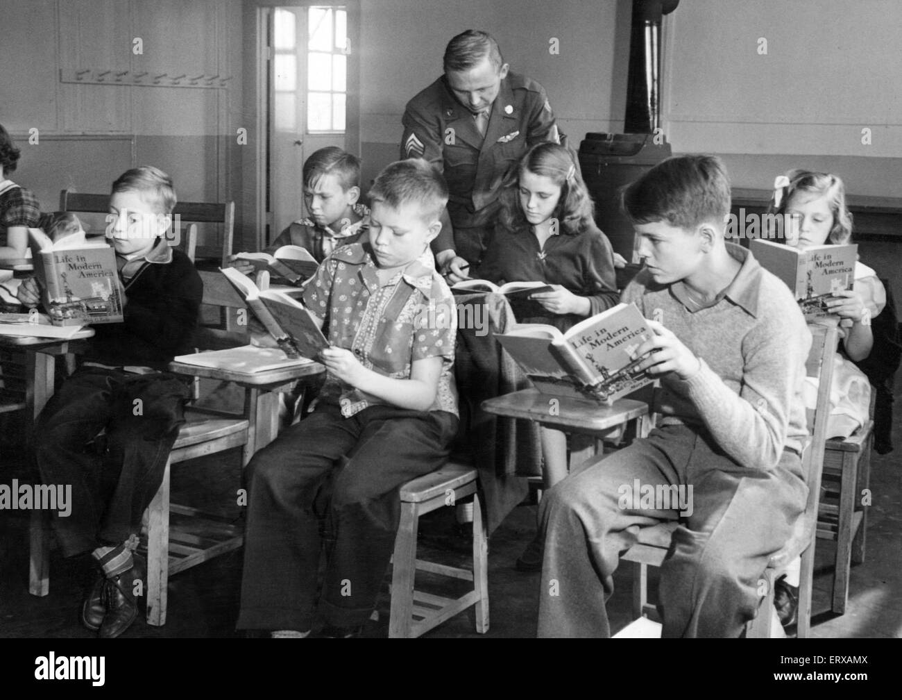 Burtonwood, US Air Base Dependents School, also known as Base Air Depot 1 (BAD 1), located 2 miles northwest of Warrington, Lancashire, England. Sergeant H M Tracy talking with Jannette Moore, aged 14, in the new school this morning. 12th September 1949. Stock Photo