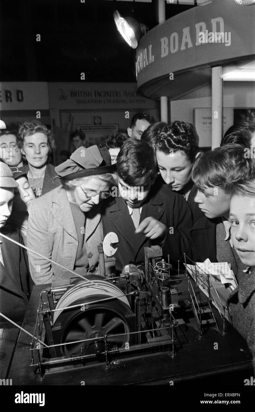 School boys and women at the 1948 Model Engineer Exhibition at Seymour Hall, London. Children and women looking at a model of winding gear. January 1948 Stock Photo