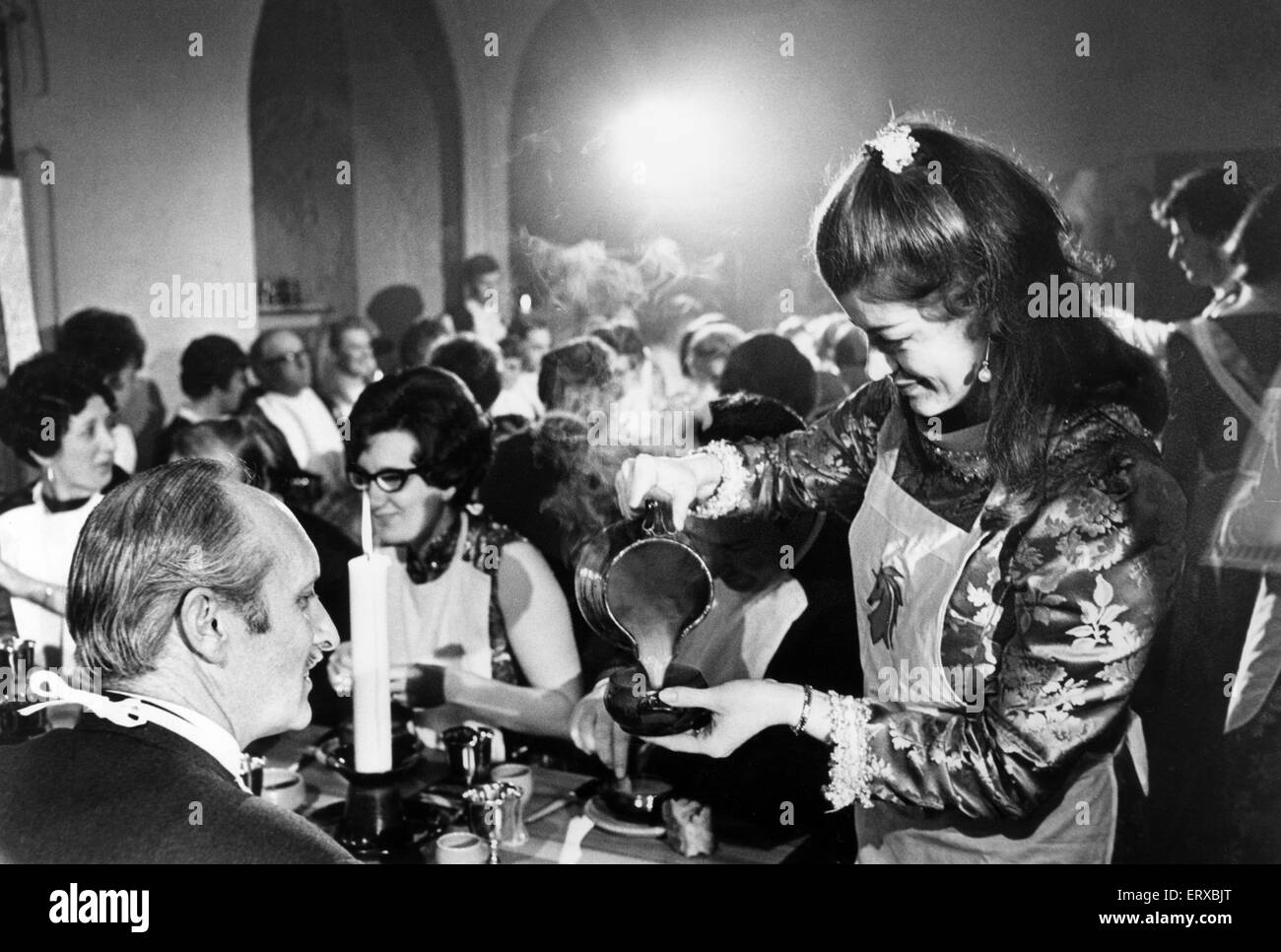 Caldicot Castle, Monmouth, southeast Wales, 19th March 1969. The opening night of the Mediaeval banquets at Caldicot Castle. Pictured, Gillian Johnson of Cwmbran, pouring soup for the guests at the table. Stock Photo