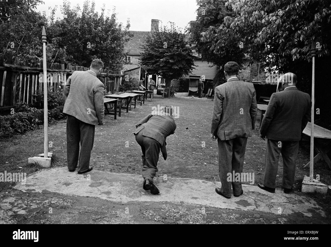 A group of men enjoy a game of Bat and Trap at a pub in Kent. Bat and trap is an English bat-and-ball pub game. It is still played in Kent, and occasionally in Brighton. August 1947. Stock Photo