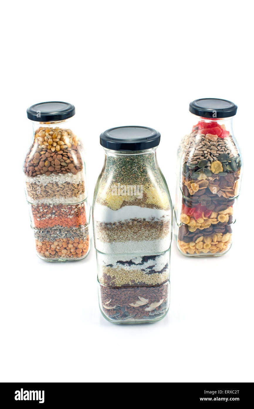 Decorative glass bottles with seeds isolated on white Stock Photo