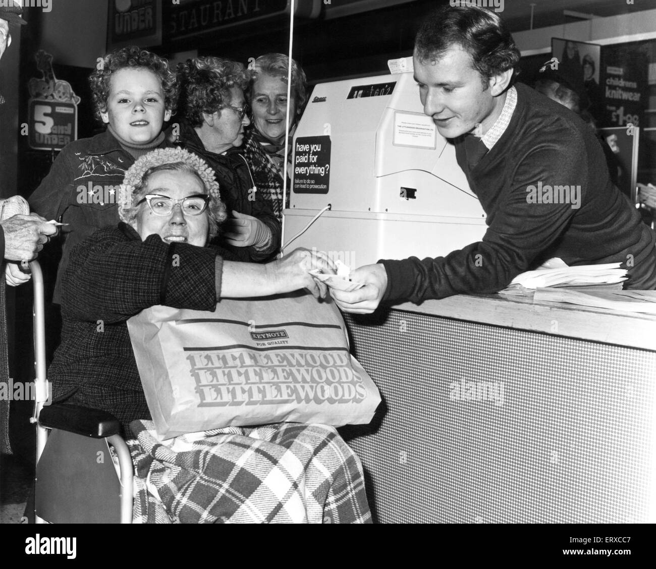 Gladys Davies, 73 from Wallasey, guided by her 10 year old grandson Michael, completes her Christmas Shopping after hours, as shops in Wallasey stayed open late exclusively for the disabled, handicapped and elderly, 6th December 1977. Stock Photo