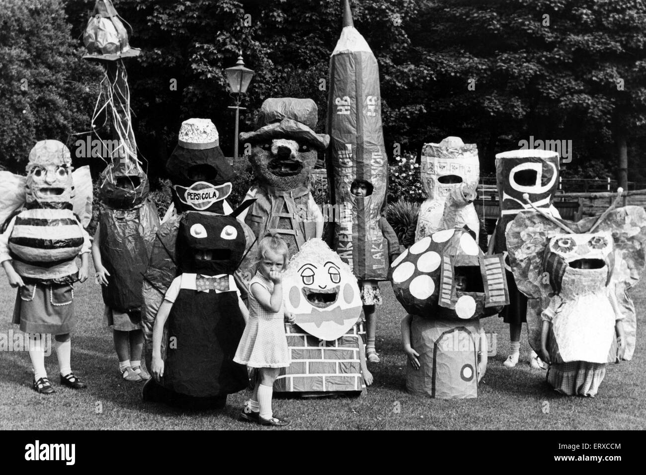 Three-year-old Helen Place of Saltburn looks on as children from Northtrifts play school model costumes made for them by pupils of Saltburn JUnior School and Huntcliff school for next week's Saltburn Carnival parade. 2nd July 1979. Stock Photo