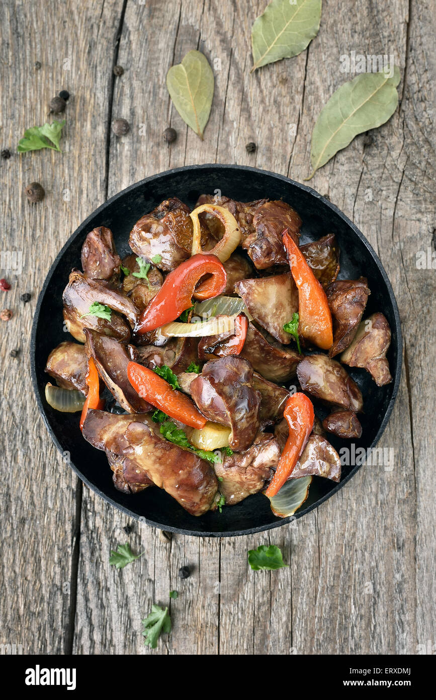 Grilled chicken liver with red pepper in frying pan on wooden table, top view Stock Photo Alamy