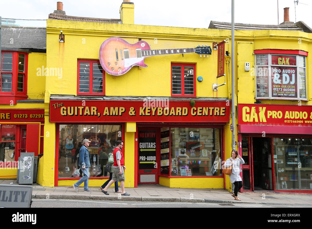 Pedestrians walk past The Guitar Amp & Keyboard Centre on North Road in