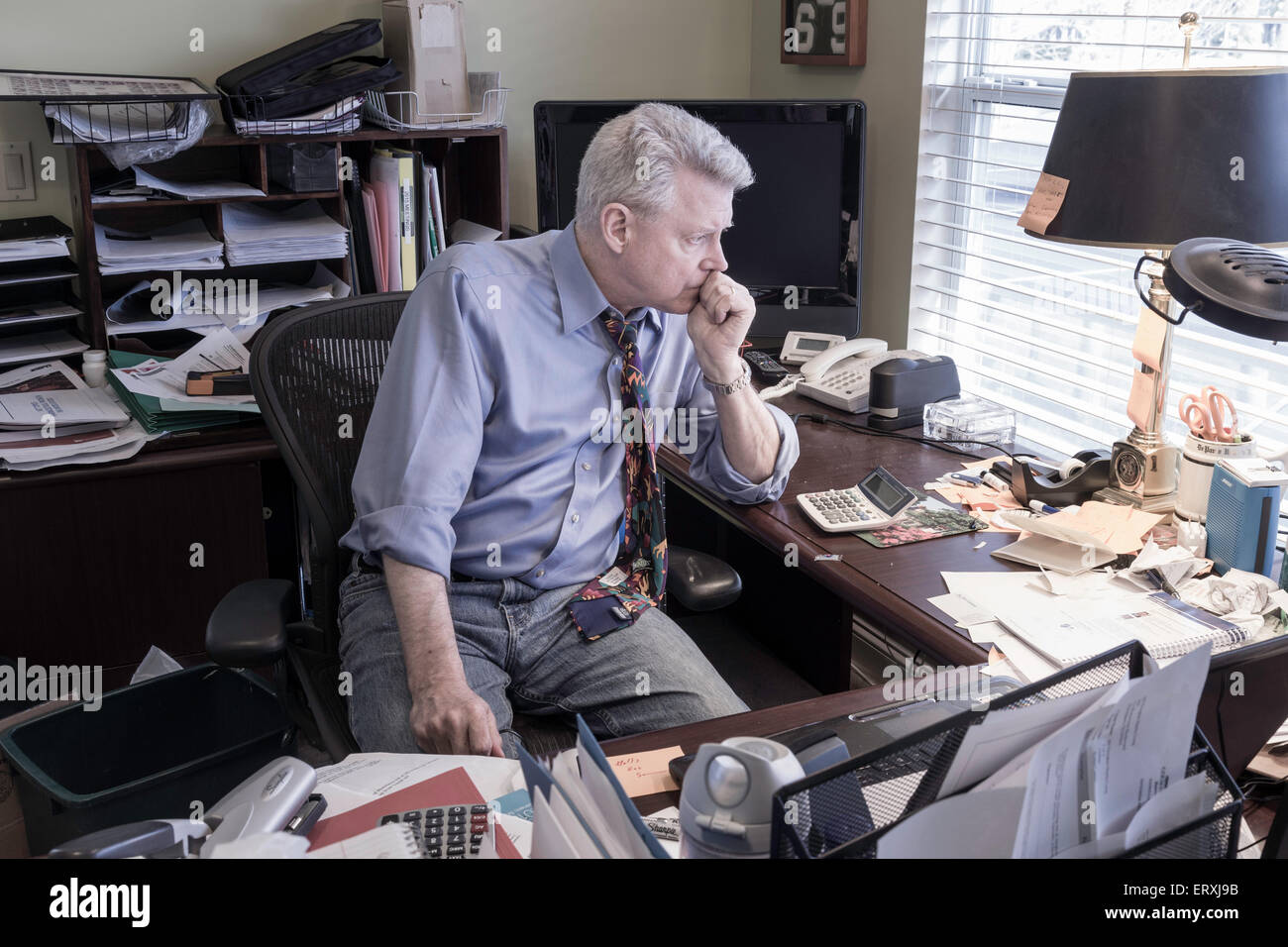 Businessman in Hoarders' Messy Home Office, USA Stock Photo 83563687