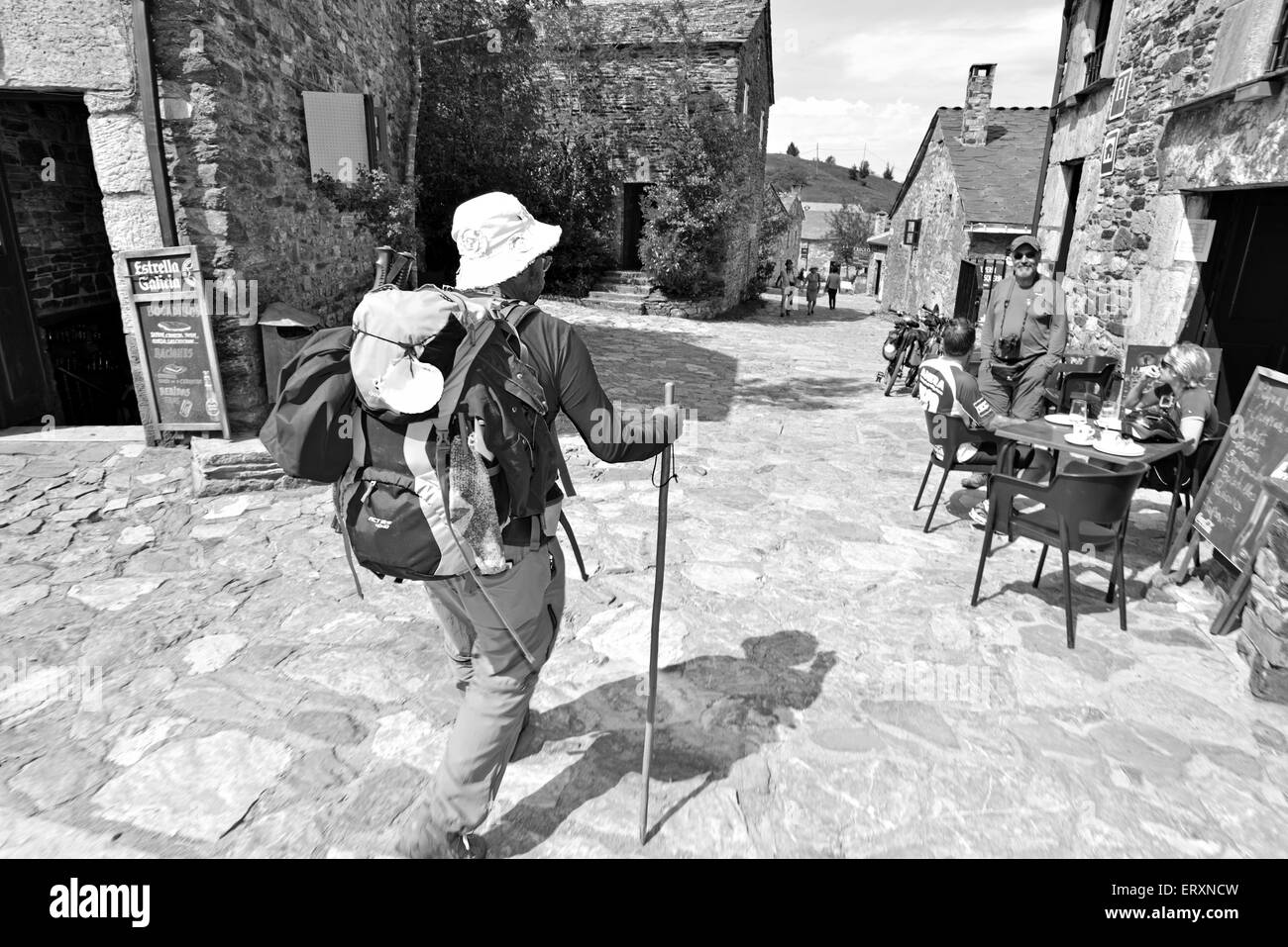 Spain, Galicia: St. James pilgrim arriving in mystic mountain village O Cebreiro meeting his hiking friends in black and white Stock Photo