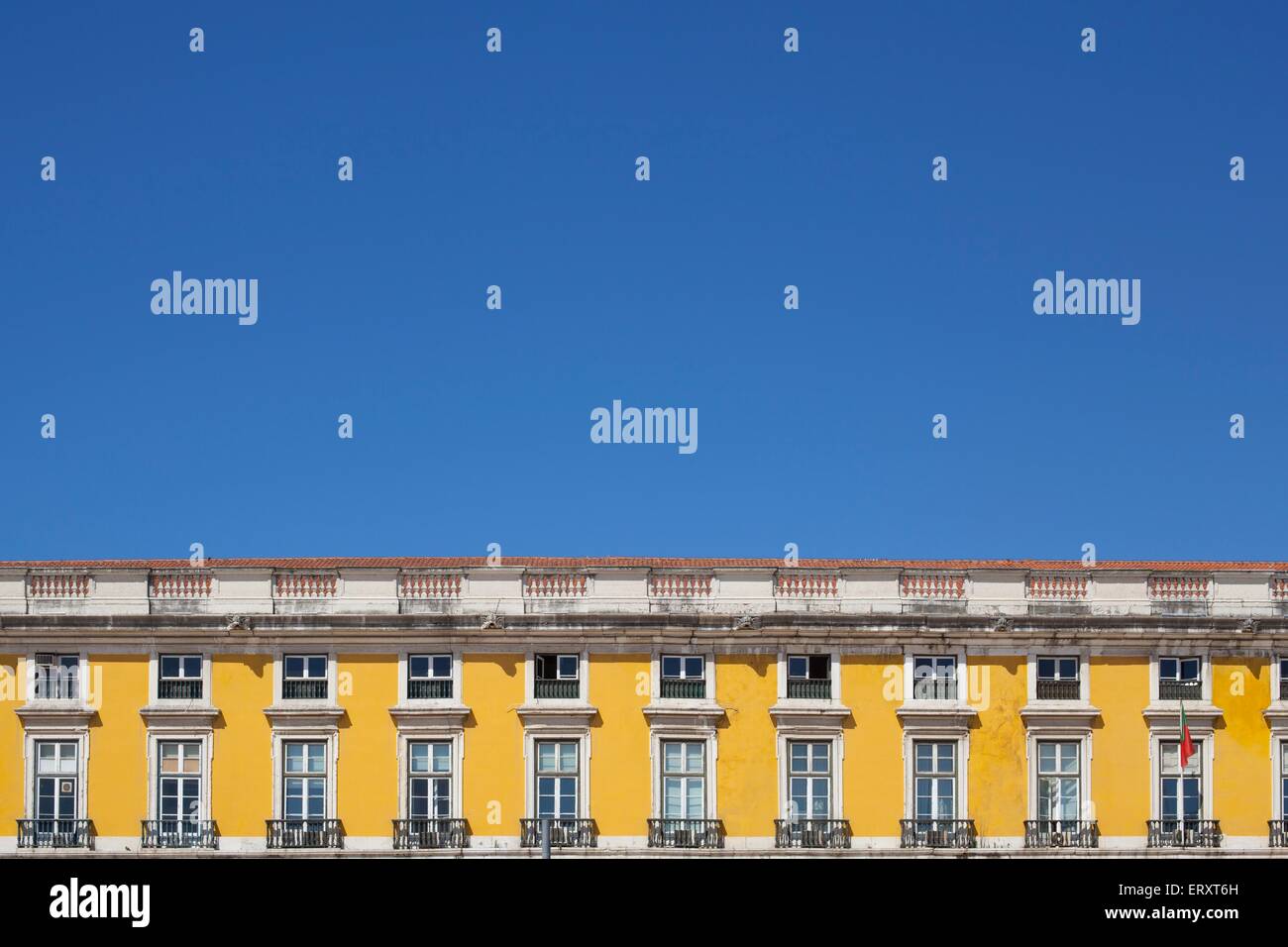 Colourful buildings in Praca de Comercio of Lisbon against a bright blue sky in summer Stock Photo