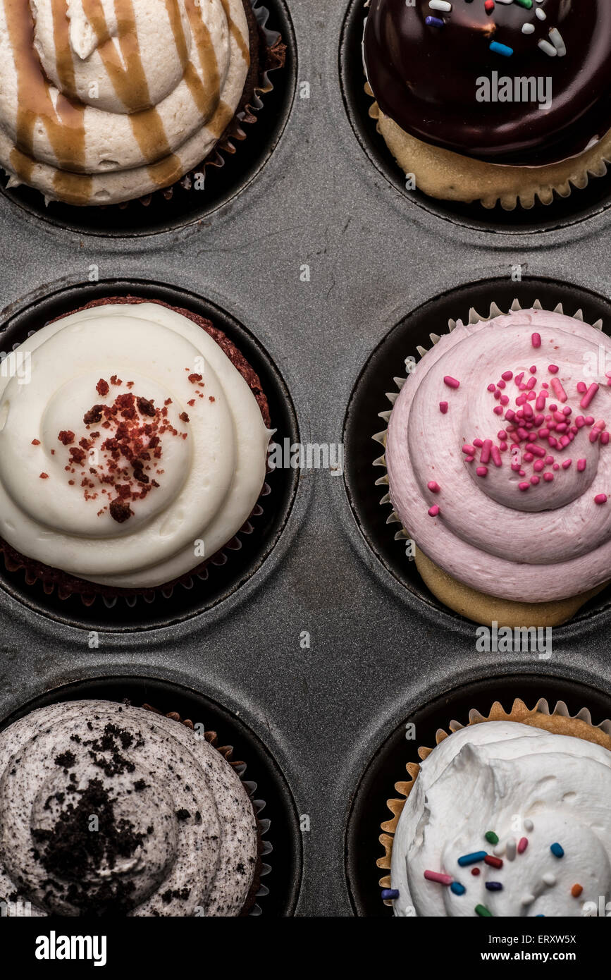 A cupcake pan with a variety of cupcake flavors. Stock Photo