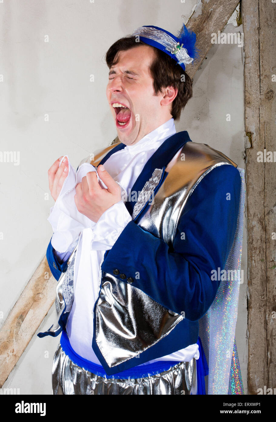 man dressed as a prince with a blue hat is about to sneeze Stock Photo