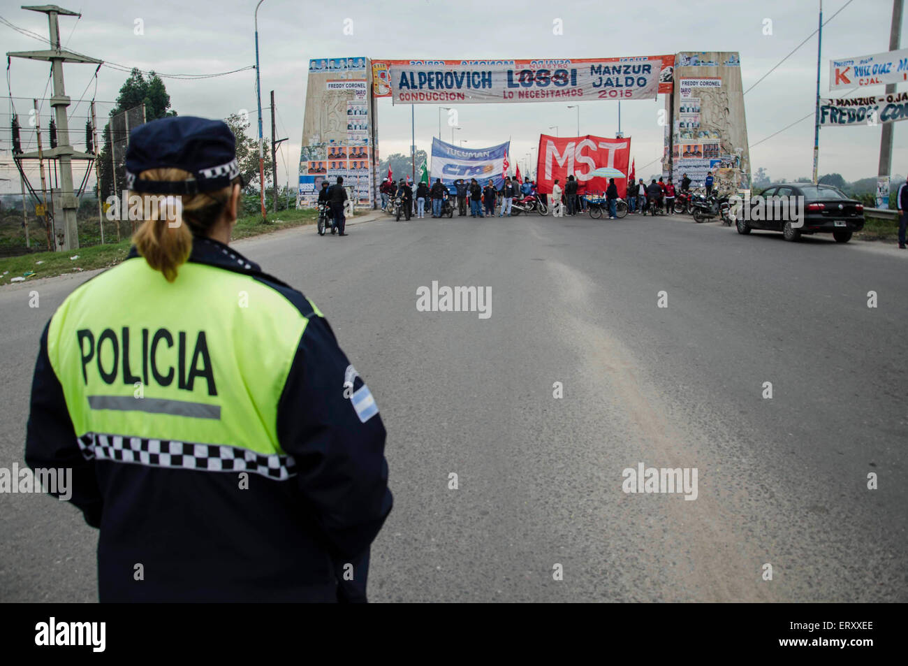 San Miguel De Tucuman, Argentina. 9th June, 2015. A policewoman observes while people take part in the blockade of an avenue during the day of national strike of transportation and several other public services, in San Miguel de Tucuman, capital of Tucuman province, northwest Argentina, on June 9, 2015. © Julio Pantoja/TELAM/Xinhua/Alamy Live News Stock Photo