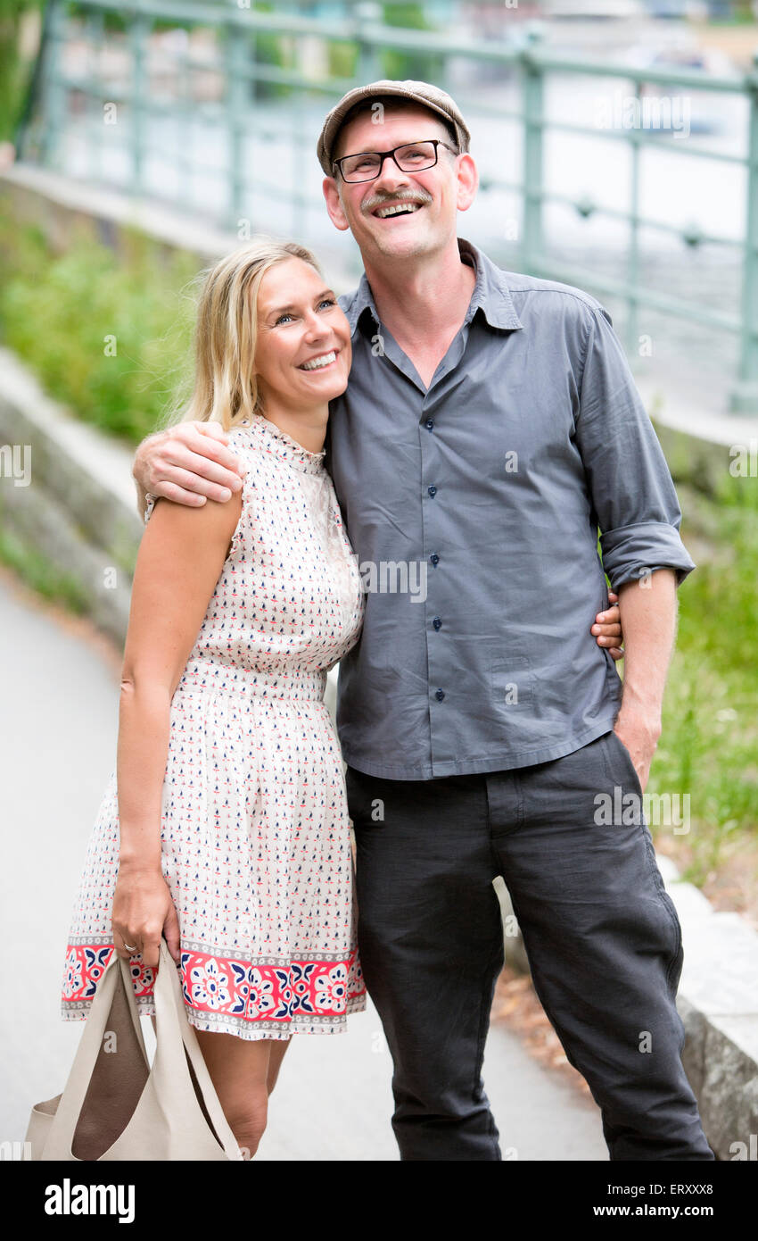 couple walking in a park alongside the water Stock Photo - Alamy