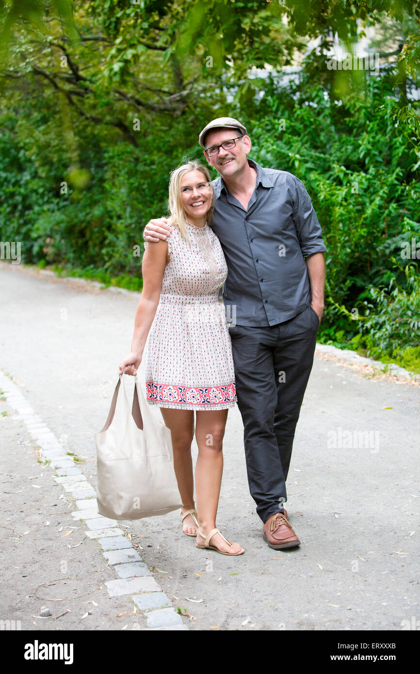 couple walking in a park and smiling Stock Photo - Alamy